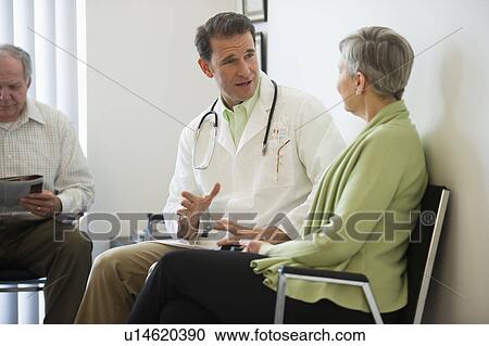 Stock Image - Senior couple talking to doctor. Fotosearch