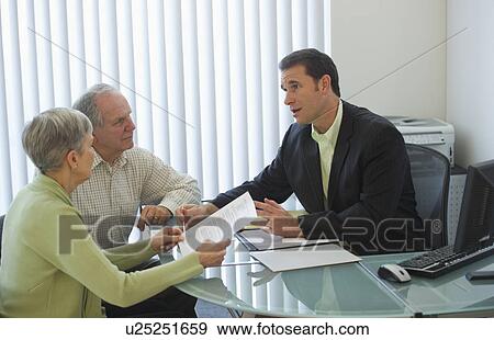 Senior couple talking to man in office View Large Photo Image Stock Photo - Senior couple talking to man in office. Fotosearch