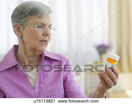 Senior woman looking at pill bottle View Large Photo Image Stock Image - Senior woman looking at pill bottle. Fotosearch