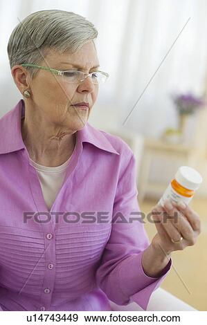 Senior woman looking at pill bottle View Large Photo Image Stock Photo - Senior woman looking at pill bottle. Fotosearch