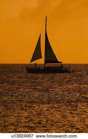 Silhouette of sailboat at sunset View Large Photo Image Stock Photo - Silhouette of sailboat at sunset. Fotosearch