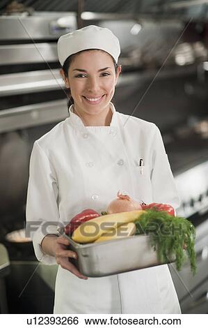 Stock Photograph - Smiling chef holding fresh vegetables. Fotosearch
