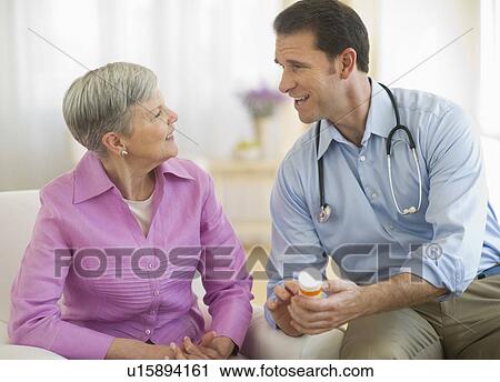 Smiling doctor giving medicine bottle to senior woman View Large Photo Image Stock Image - Smiling doctor giving medicine bottle to senior woman. Fotosearch