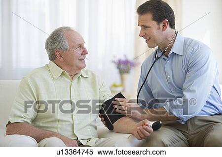Stock Photography - Smiling man taking senior man's blood pressure. Fotosearch