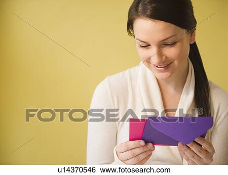 Smiling young woman holding letter View Large Photo Image Stock Photograph - Smiling young woman holding letter. Fotosearch