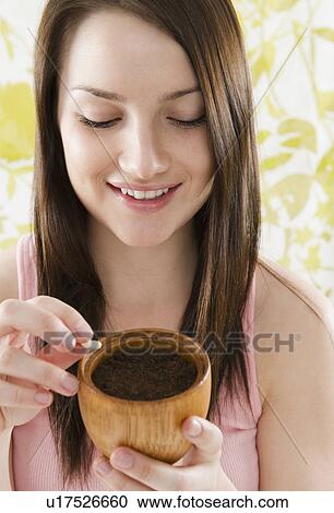 Smiling young woman holding pot with soil and bean View Large Photo Image Stock Image - Smiling young woman holding pot with soil and bean. Fotosearch