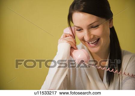 Stock Photo - Smiling young woman talking on phone. Fotosearch
