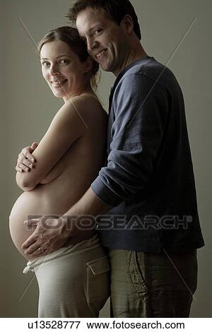 Stock Photo - Studio portrait of expectant couple. Fotosearch