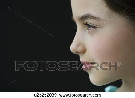 Stock Photo - Studio profile of girl (8-9) on black background. Fotosearch