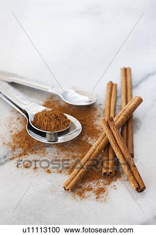 Stock Image - Studio shot of cinnamon stick and cinnamon powder. Fotosearch