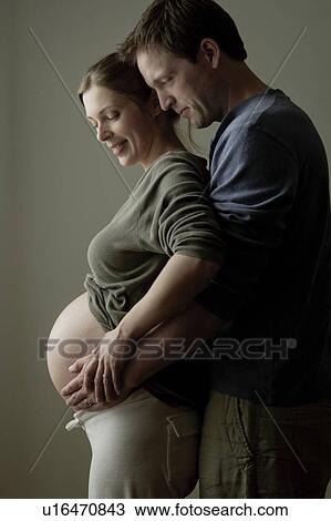 Stock Image - Studio shot of expectant couple. Fotosearch
