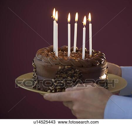 Studio shot of man holding chocolate birthday cake View Large Photo Image Stock Image - Studio shot of man holding chocolate birthday cake. Fotosearch