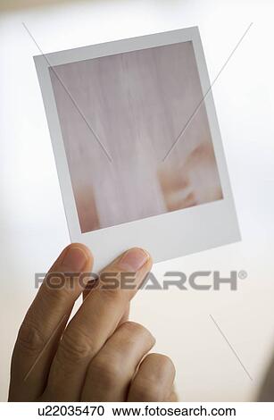 Studio shot of man's hand holding Polaroid photograph View Large Photo Image Stock Image - Studio shot of man's hand holding Polaroid photograph. Fotosearch