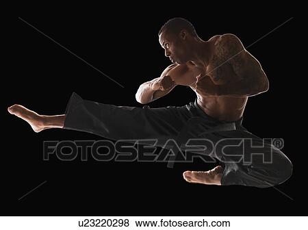 Studio shot of martial arts practitioner in mid-air kick View Large Photo Image Stock Photo - Studio shot of martial arts practitioner in mid-air kick. Fotosearch