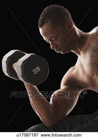 Studio shot of muscular man exercising with dumbbells View Large Photo Image Stock Photo - Studio shot of muscular man exercising with dumbbells. Fotosearch