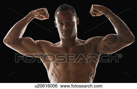 Stock Photograph - Studio shot of muscular man flexing muscles. Fotosearch