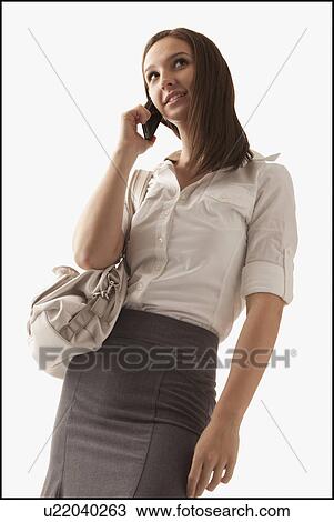 Studio shot of young woman with mobile phone View Large Photo Image Stock Image - Studio shot of young woman with mobile phone. Fotosearch