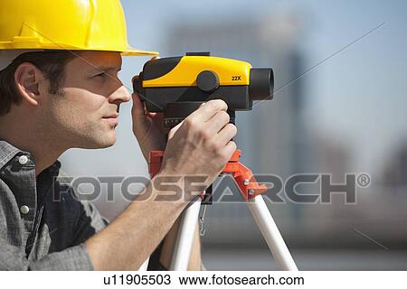 Stock Image - Surveyor using theodolite. Fotosearch
