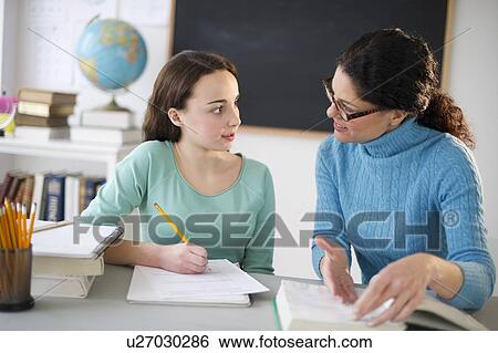Stock Photograph - Teacher talking to teenage girl (14-15). Fotosearch