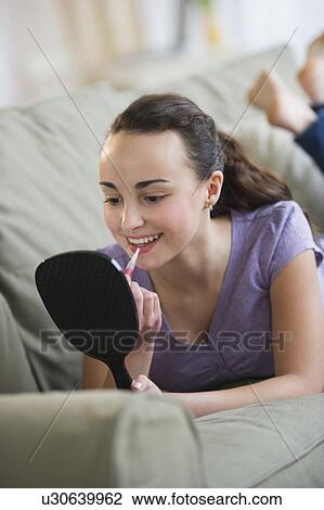 Teenage girl (14-15) applying lipstick View Large Photo Image Stock Image - Teenage girl (14-15) applying lipstick. Fotosearch