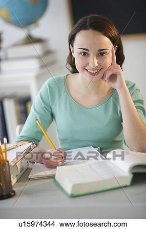 Picture - Teenage girl (14-15) doing homework. Fotosearch