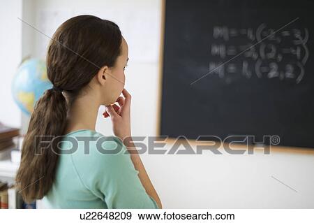 Teenage girl (14-15) looking at blackboard View Large Photo Image Stock Photo - Teenage girl (14-15) looking at blackboard. Fotosearch