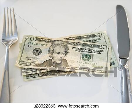 Stock Image - Twenty dollar bills on place settings, studio shot. Fotosearch