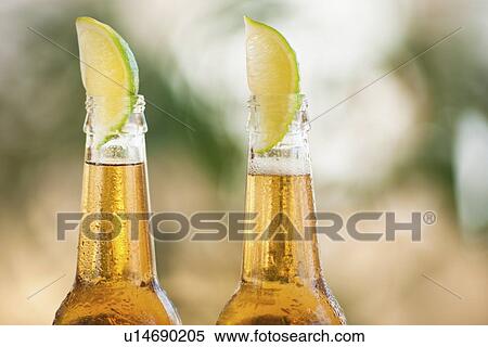 Two beer bottles with lime wedges View Large Photo Image Stock Photography - Two beer bottles with lime wedges. Fotosearch