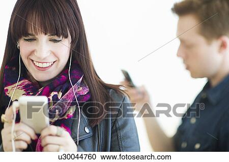 Two young people with mp3 players View Large Photo Image Stock Image - Two young people with mp3 players. Fotosearch