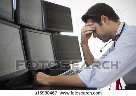 Stock Photo - Upset financial worker analyzing data displayed on computer screen. Fotosearch