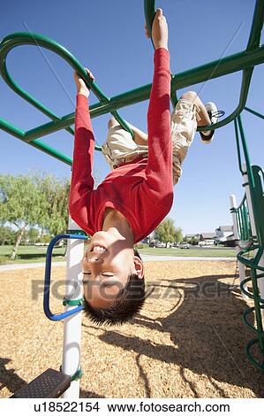 Picture - USA, California, Boy (12-13) climbing at playground. Fotosearch