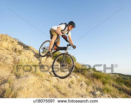 Stock Image - USA, California, Laguna Beach, Man cycling down hill. Fotosearch