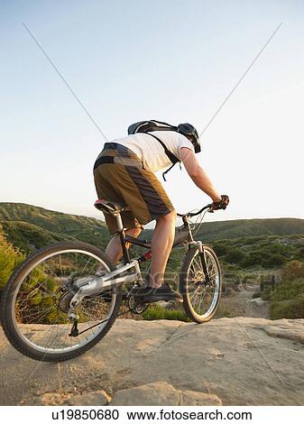 Stock Image - USA, California, Laguna Beach, Man cycling down hill. Fotosearch