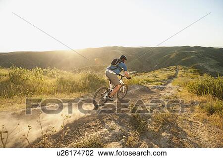 Stock Image - USA, California, Laguna Beach, Man cycling down hill. Fotosearch