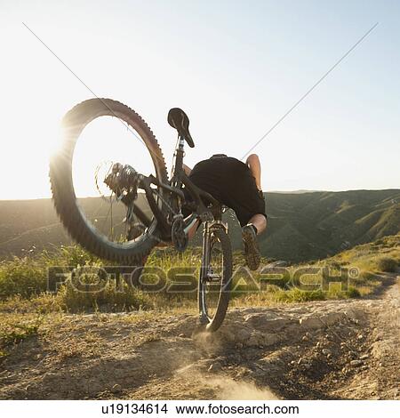 Picture - USA, California, Laguna Beach, Mountain biker falling of his bike. Fotosearch