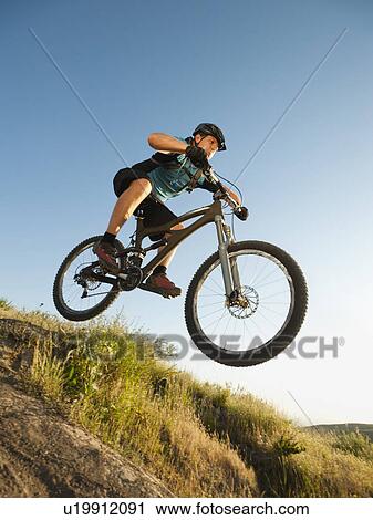USA, California, Laguna Beach, Mountain biker jumping downhill on his bike View Large Photo Image Stock Image - USA, California, Laguna Beach, Mountain biker jumping downhill on his bike. Fotosearch