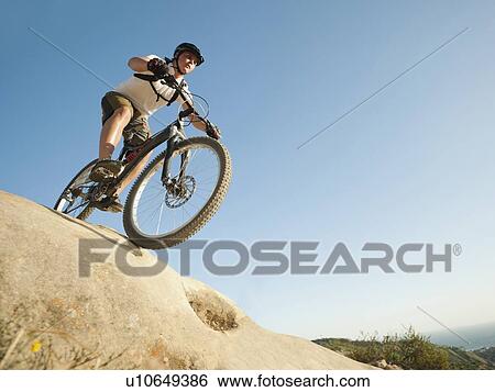 Stock Photograph - USA, California, Laguna Beach, Mountain biker riding downhill. Fotosearch