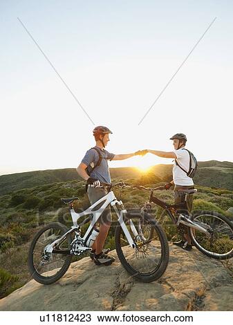 USA, California, Laguna Beach, Two bikers on hill doing fist bump View Large Photo Image Stock Image - USA, California, Laguna Beach, Two bikers on hill doing fist bump. Fotosearch