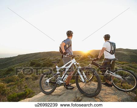 USA, California, Laguna Beach, Two bikers on hill looking at view View Large Photo Image Stock Photo - USA, California, Laguna Beach, Two bikers on hill looking at view. Fotosearch