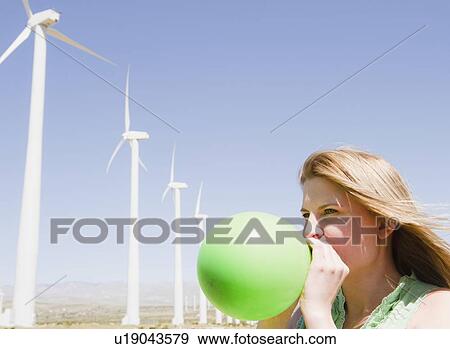 USA, California, Palm Springs, Coachella Valley, San Gorgonio Pass, Woman blowing green balloon with wind turbines in background View Large Photo Image Stock Photo - USA, California, Palm Springs, Coachella Valley, San Gorgonio Pass, Woman blowing green balloon with wind turbines in background. Fotosearch