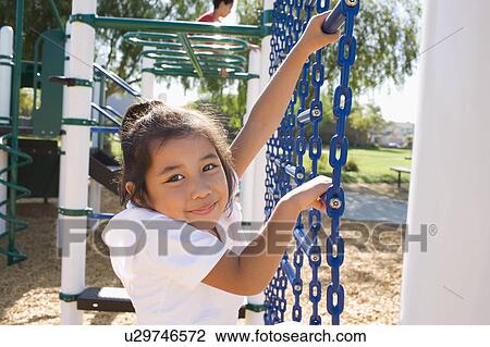 Stock Image - USA, California, Portrait of girl (4-5) climbing at playground. Fotosearch