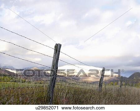 Stock Image - USA, Colorado, Mountain landscape with fence in foreground. Fotosearch