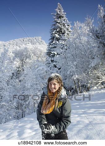 Stock Photo - USA, Colorado, portrait of young woman in winter landscape. Fotosearch