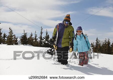 Picture - USA, Colorado, Telluride, Father and daughter (10-11) posing with snowboards in winter scenery. Fotosearch