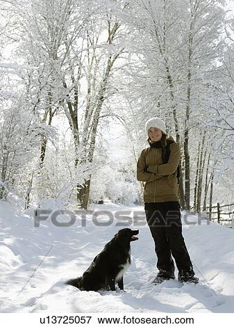 USA, Colorado, young woman playing with dog on snowy road View Large Photo Image Stock Photo - USA, Colorado, young woman playing with dog on snowy road. Fotosearch