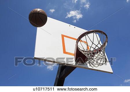 Stock Image - USA, Florida, Miami, Low angle view of basketball flying into hoop. Fotosearch