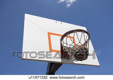 Stock Image - USA, Florida, Miami, Low angle view of basketball hoop with basketball inside. Fotosearch