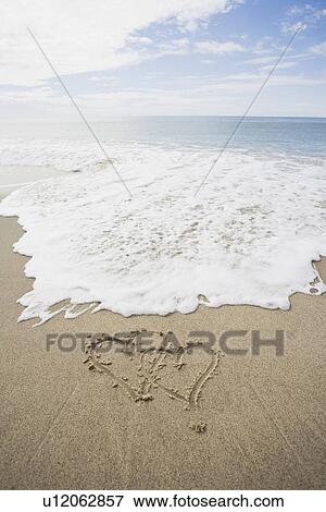 Stock Photo - USA, Massachusetts, Hearts drawn on sandy beach. Fotosearch