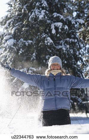 Stock Image - USA, Montana, Whitefish, Woman playing in snow. Fotosearch