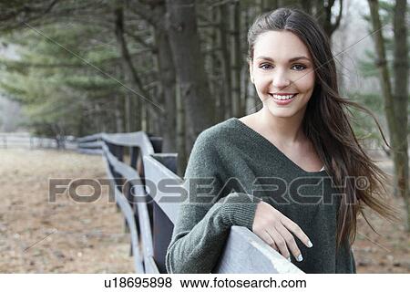 USA, New Jersey, Califon, Teenage girl (16-17) standing near fence and looking at camera, portrait View Large Photo Image Stock Photo - USA, New Jersey, Califon, Teenage girl (16-17) standing near fence and looking at camera, portrait. Fotosearch